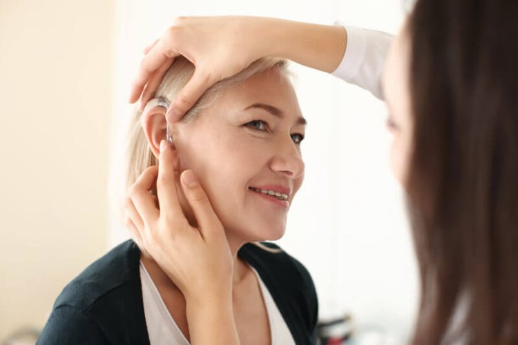 woman inserting a hearing aid