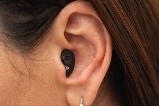 woman using in the ear hearing aid