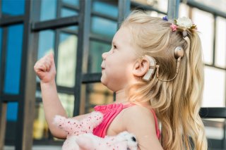 young girl with a surgical hearing aid